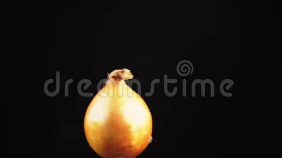 洋葱特写水滴落在黑色背景上旋转的苹果上超级慢动作视频的预览图