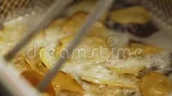 新鲜煮熟的牛排切出新鲜的炸锅里的热油土豆是在深油炸锅里煮的视频的预览图