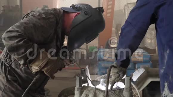 工厂工人带防护面罩焊接金属均匀框架一个人在艰苦的工作过程中焊接金属视频的预览图