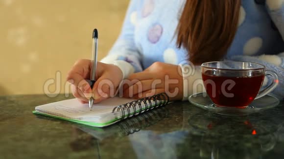 女人写日记桌上放着一杯茶视频的预览图