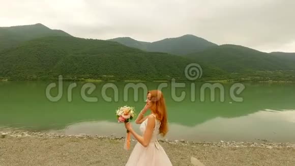 河岸上美丽幸福的新郎新娘新娘抛出一束婚礼花束视频的预览图