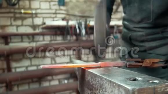 自动机械锤击铁匠在铁砧上锻造红铁长焦视频的预览图