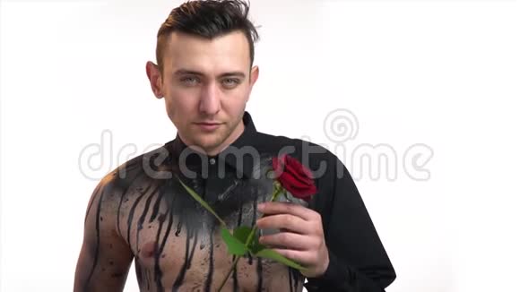 肌肉男在黑色身体艺术给一朵红玫瑰视频的预览图