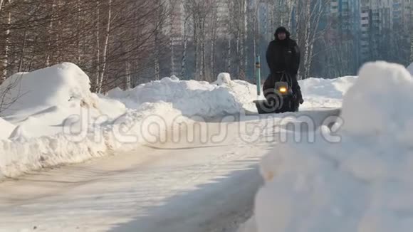 在冬季的道路上人们骑着带拖车的履带式微型雪车视频的预览图