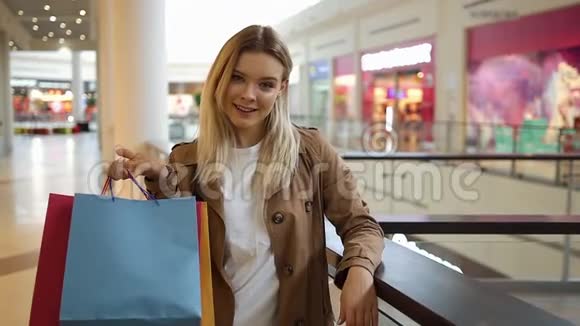 迷人的女人把购物袋放在肩上站在商场里视频的预览图
