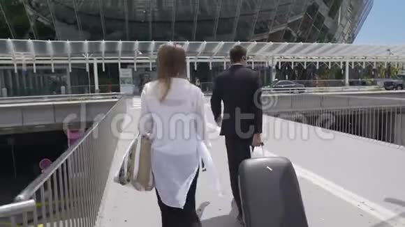 迷人的女性和保镖带着她的行李在机场散步旅游视频的预览图