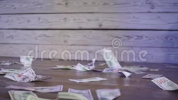 美元钞票的钞票散落在空中的木地板和墙壁上的背景朱门视频的预览图