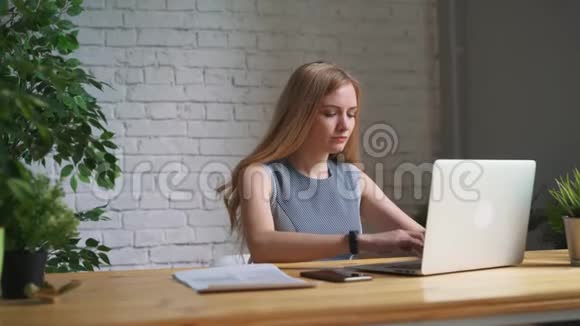 女人关上笔记本电脑结束工作日视频的预览图