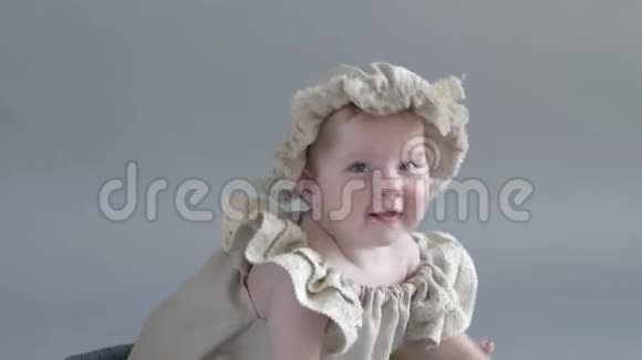 穿着头饰和衣服的小女孩坐在木箱里在照相机上摆姿势视频的预览图