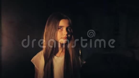 一个年轻漂亮的女孩留着长长的黑发在黑暗中行走白色裙子害怕了视频的预览图