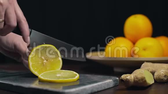 柠檬是用锋利的刀在岩石板上切片新鲜的橙色切片水果和维生素素食制作视频的预览图