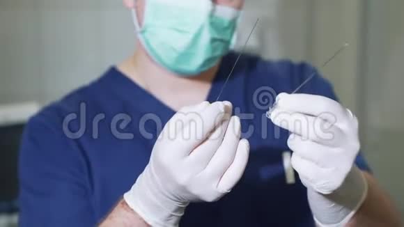 外科医生演示了一根大金属针医生用无菌手套检查医疗设备针状物视频的预览图
