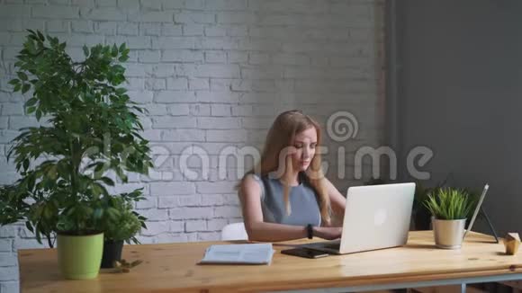 女人关上笔记本电脑结束工作日视频的预览图