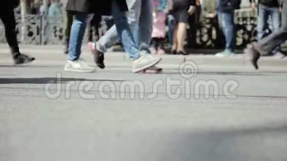 近距离观看人的脚在拥挤的街道上行走人群在街上行走的腿视频的预览图