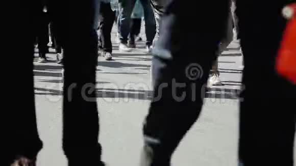近距离观看人的脚在拥挤的街道上行走人群在街上行走的腿视频的预览图