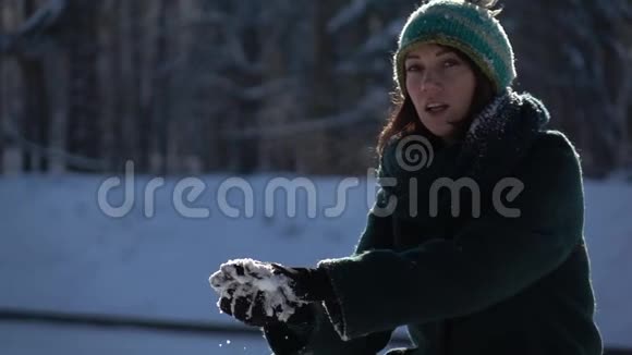 慢镜头漂亮的女孩在镜头前扔雪球视频的预览图