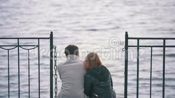 坐在河上码头欣赏大自然的年轻夫妇视频的预览图