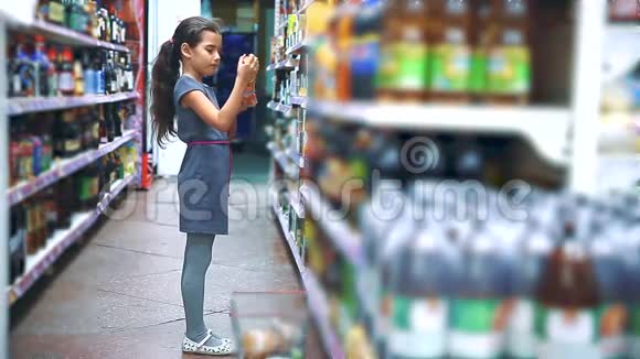 在杂货店买数字平板电脑的小女孩在网上购买柠檬汽水可乐产品一个小女孩视频的预览图