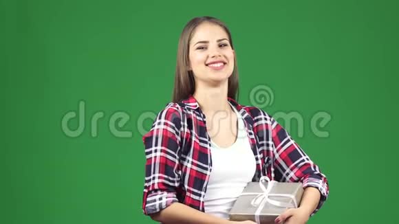 幸福的年轻美女微笑着拿着礼物对着镜头挥手视频的预览图