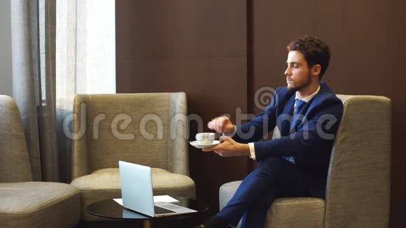 年轻的创业创业者有魅力的男性在新的令人兴奋的项目中在咖啡馆里远程工作他喝着特制的咖啡视频的预览图