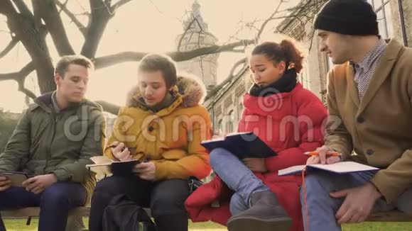 四个学生在校园附近的公园里讨论视频的预览图