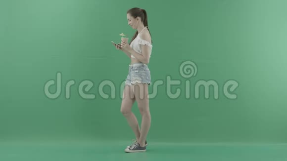 带智能手机饮料的年轻女性带绿色背景的鸡尾酒视频的预览图