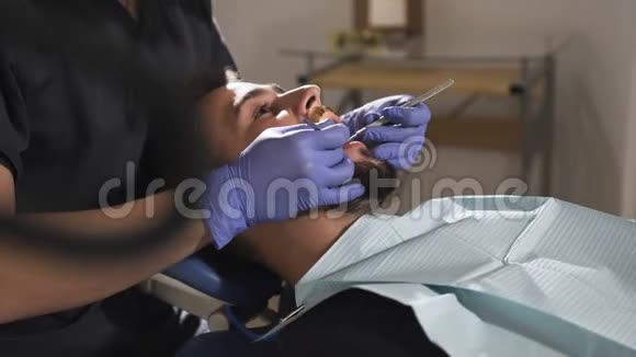 牙医检查病人牙齿健康的牙齿牙科器械视频的预览图