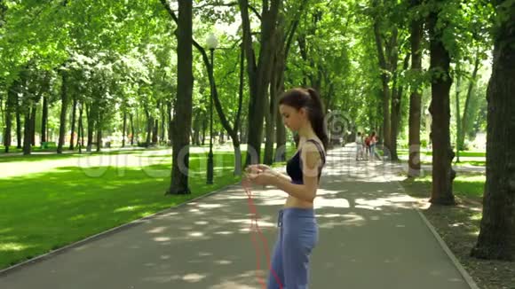 公园里的苗条女孩和跳绳视频的预览图