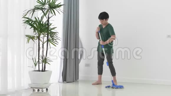 亚洲小男孩帮助家人用拖把打扫房子视频的预览图