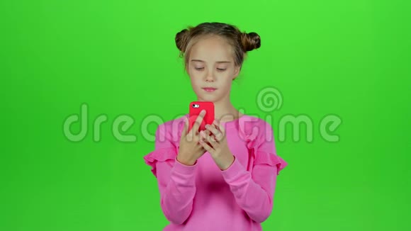 宝贝女孩在手机上自拍绿色屏幕慢动作视频的预览图