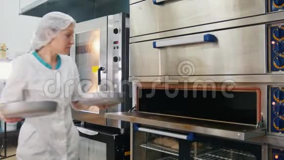 女性在商业厨房烤蛋糕女性在烤箱里烤视频的预览图