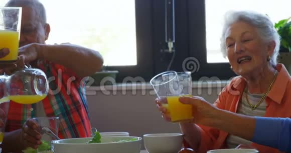 高级朋友在餐桌上品尝一杯果汁视频的预览图