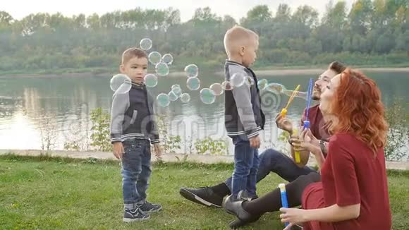 爱和父母的概念家庭幸福孩子们在户外吹肥皂泡视频的预览图