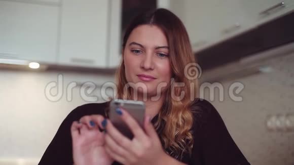 漂亮的年轻女孩用智能手机和微笑打电话给她的女朋友视频的预览图
