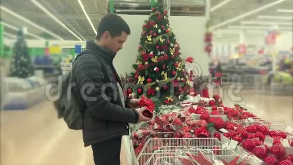 成年人正在超市为圣诞树挑选装饰品视频的预览图