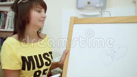 心理学家房间里的一个十几岁的女孩在黑板上画画心理测试视频的预览图