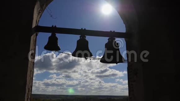 蓝天背景上的钟声伴随着云彩各种大小的钟声悬挂在高海拔的砖拱上视频的预览图