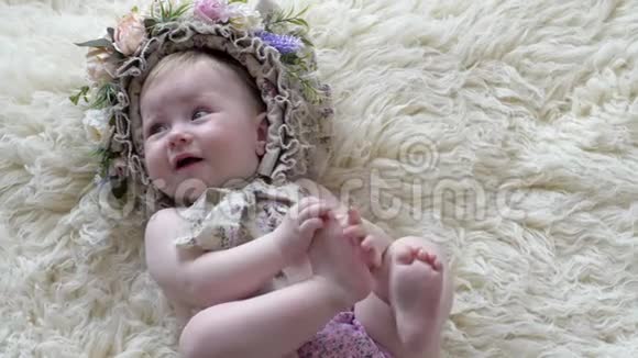 小时候抱着花的婴儿躺在地毯上对着相机拍照视频的预览图