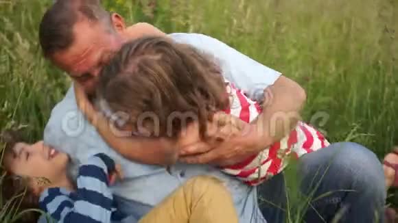爷爷正和她的孙子们在一片阳光明媚的草地上玩耍玩得开心家庭节日快乐视频的预览图