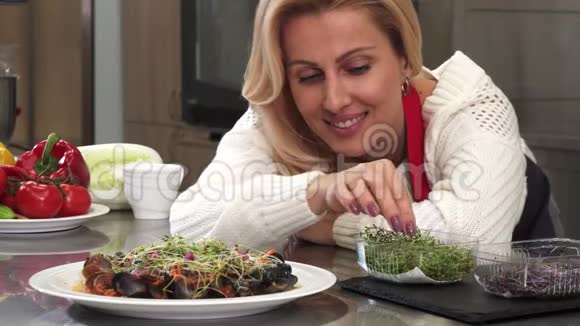 漂亮的成熟女人在厨房装饰美味的食物视频的预览图