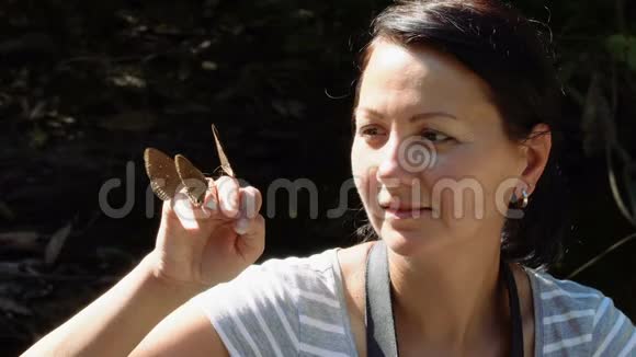 快乐的女人欣赏蝴蝶视频的预览图