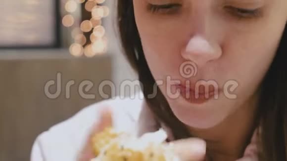 女人在咖啡馆里津津有味地吃着汉堡包视频的预览图