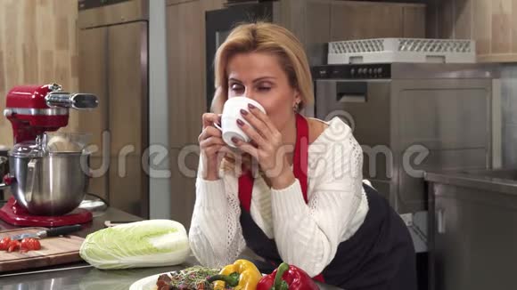 有魅力的成熟女人在家厨房喝咖啡视频的预览图