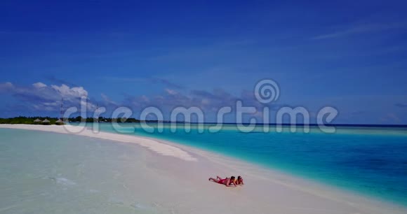 2个年轻人浪漫的情侣日光浴无人驾驶飞机在沙滩上看着白色沙滩和美丽的风景视频的预览图