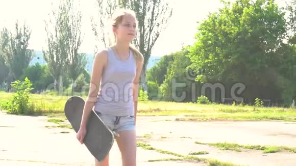 少女在阳光下用滑板行走视频的预览图