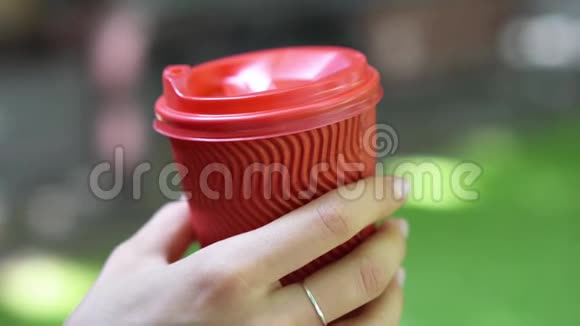户外的女人手里拿着一个红色的塑料杯视频的预览图