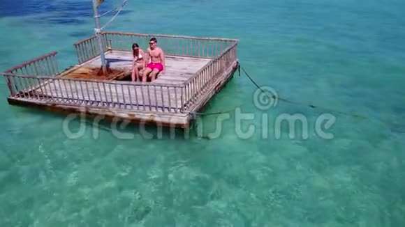 V08580两个年轻人在美丽的碧蓝的海水中在浮舟上享受浪漫的日光浴视频的预览图