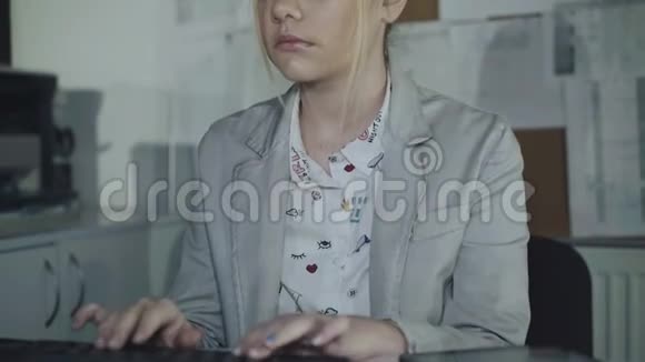 年轻女孩在键盘上打字在办公室里看着相机4K视频的预览图