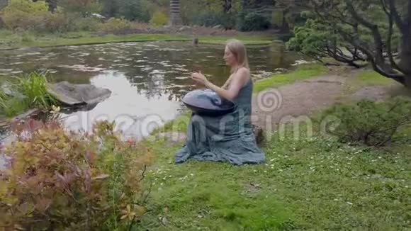 流行的现代的乐器挂在公园里一个漂亮的金发女郎手中视频的预览图