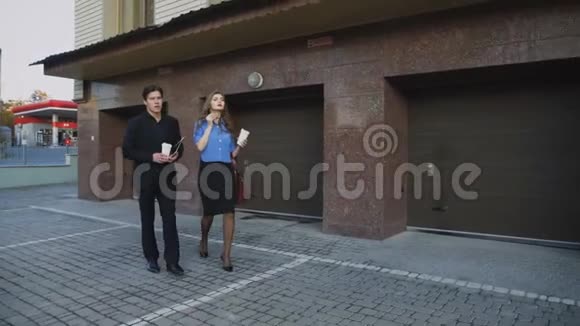 漂亮的商务情侣在办公室的车库里散步聊天视频的预览图